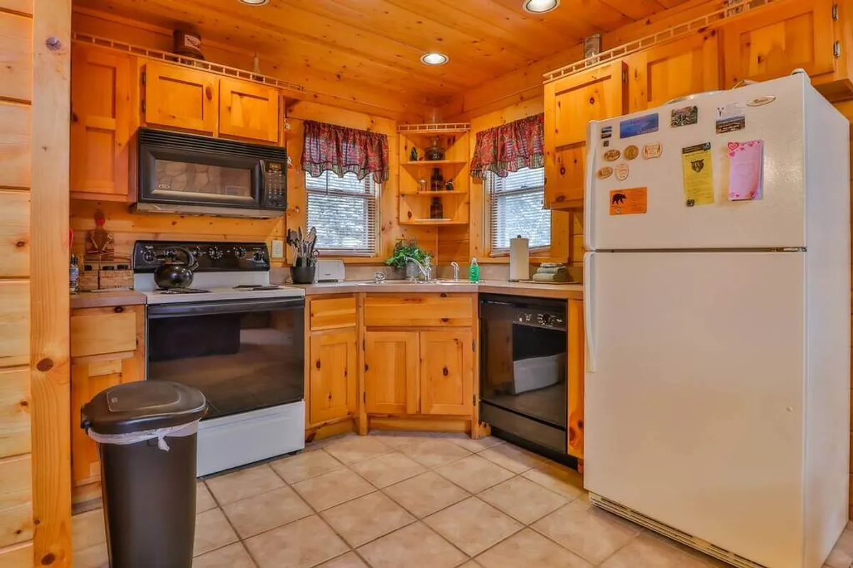 A spacious, homey kitchen with wooden cabinetry, up-to-date appliances, and a central island. The layout suggests ease of movement for cooking, socializing, and entertaining, with inviting touches that make the space feel ready for any culinary adventure.